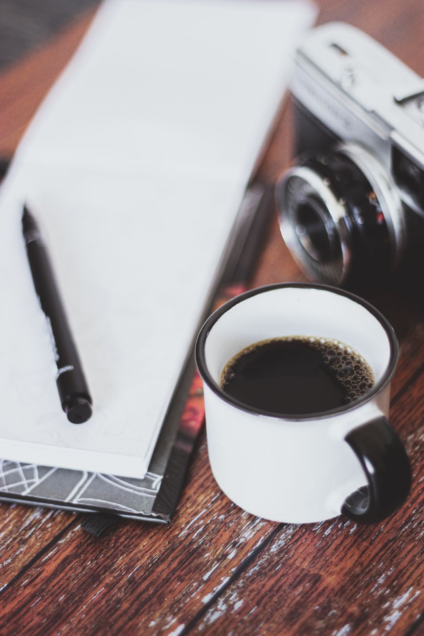 Antique leather travel diary, lenses and fountain pen on desk