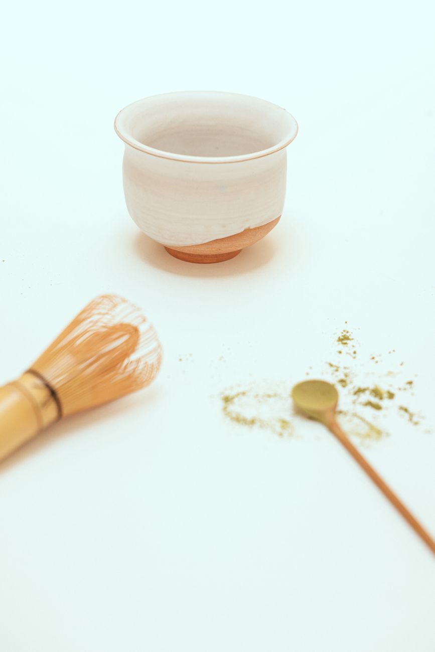 Traditional Japanese tea set with green matcha foam in quiet courtyard